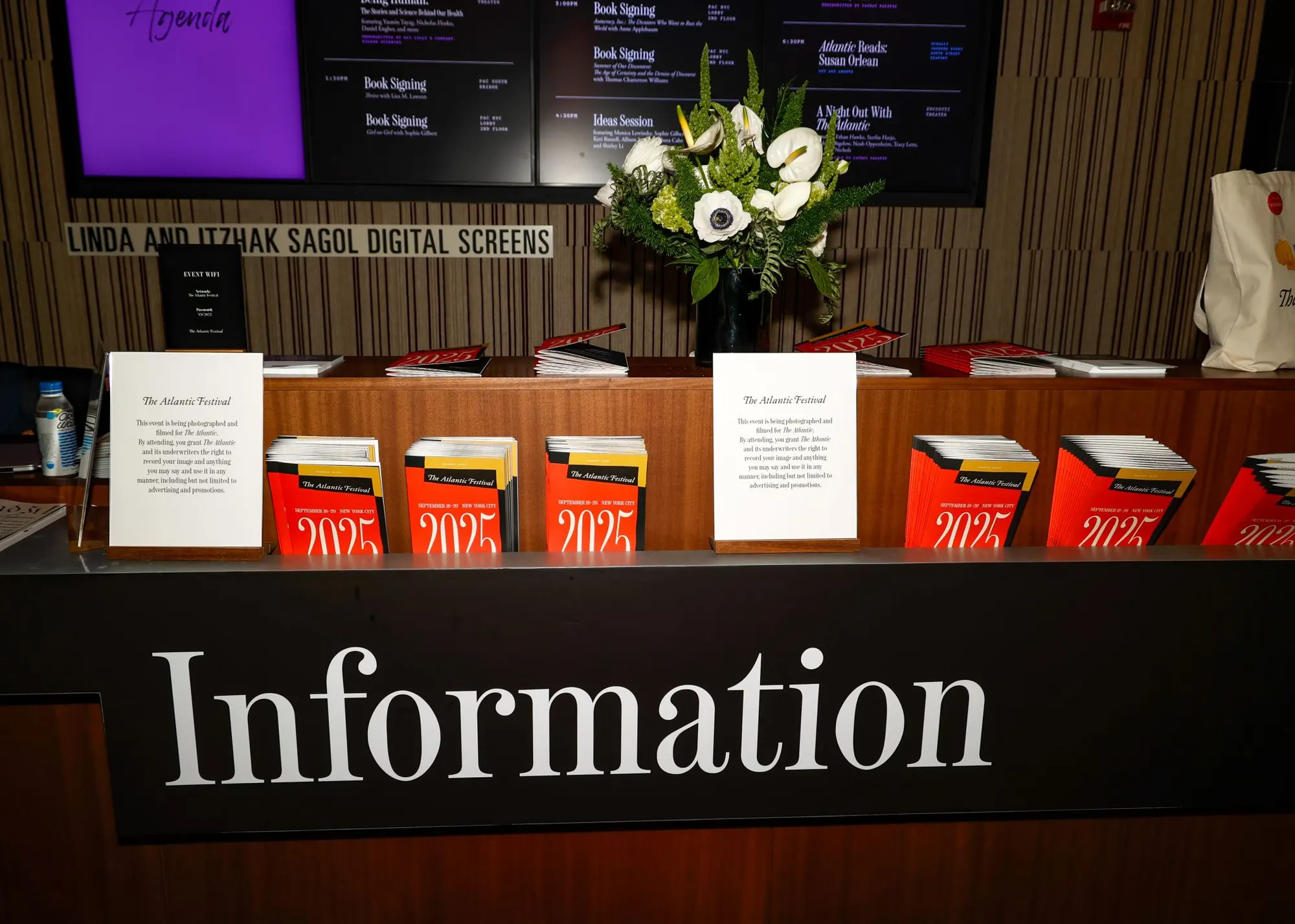 The book-signing table, festival programs stacked beside a white flower arrangement.