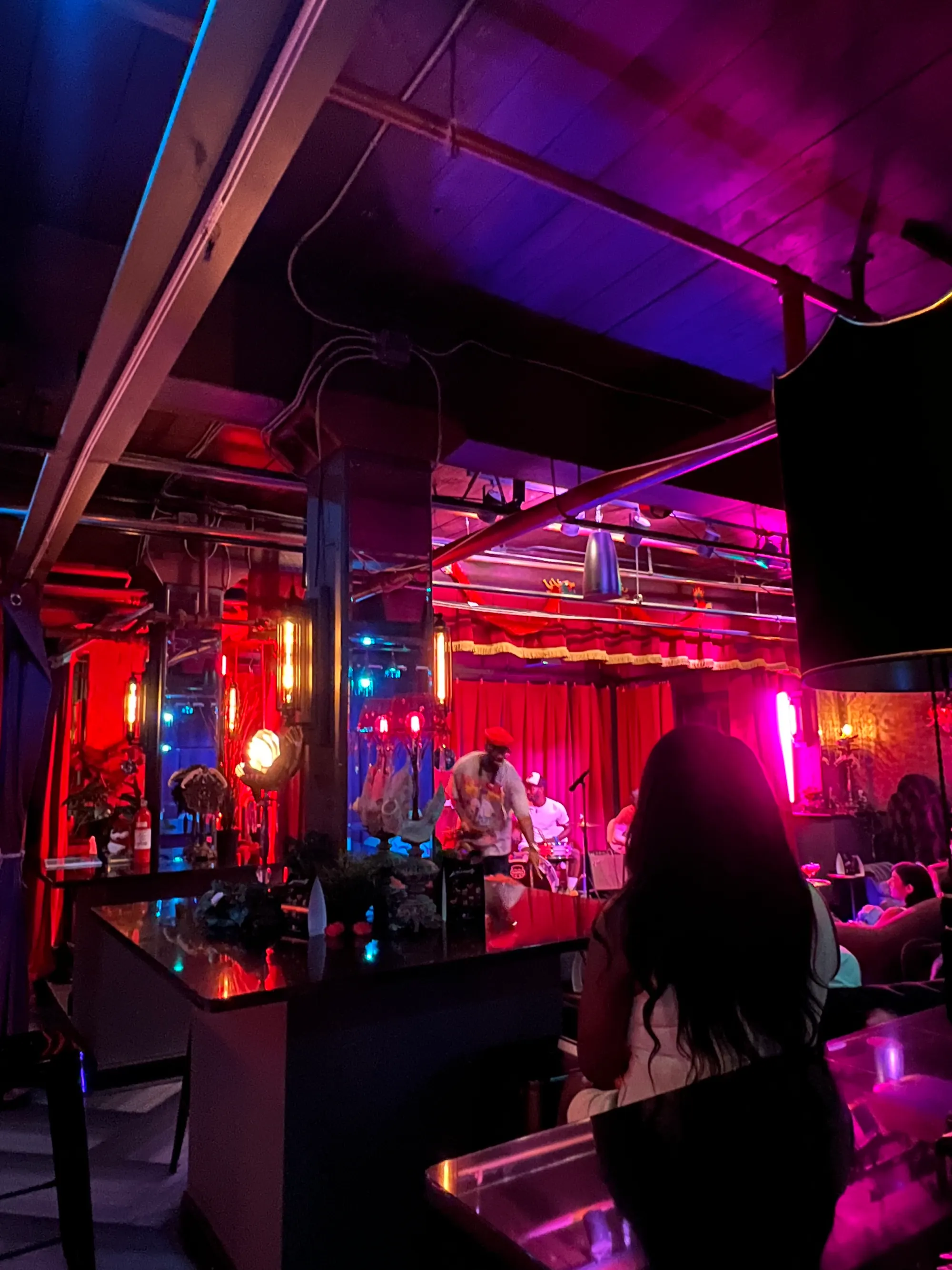 The venue interior lit in deep red and magenta.