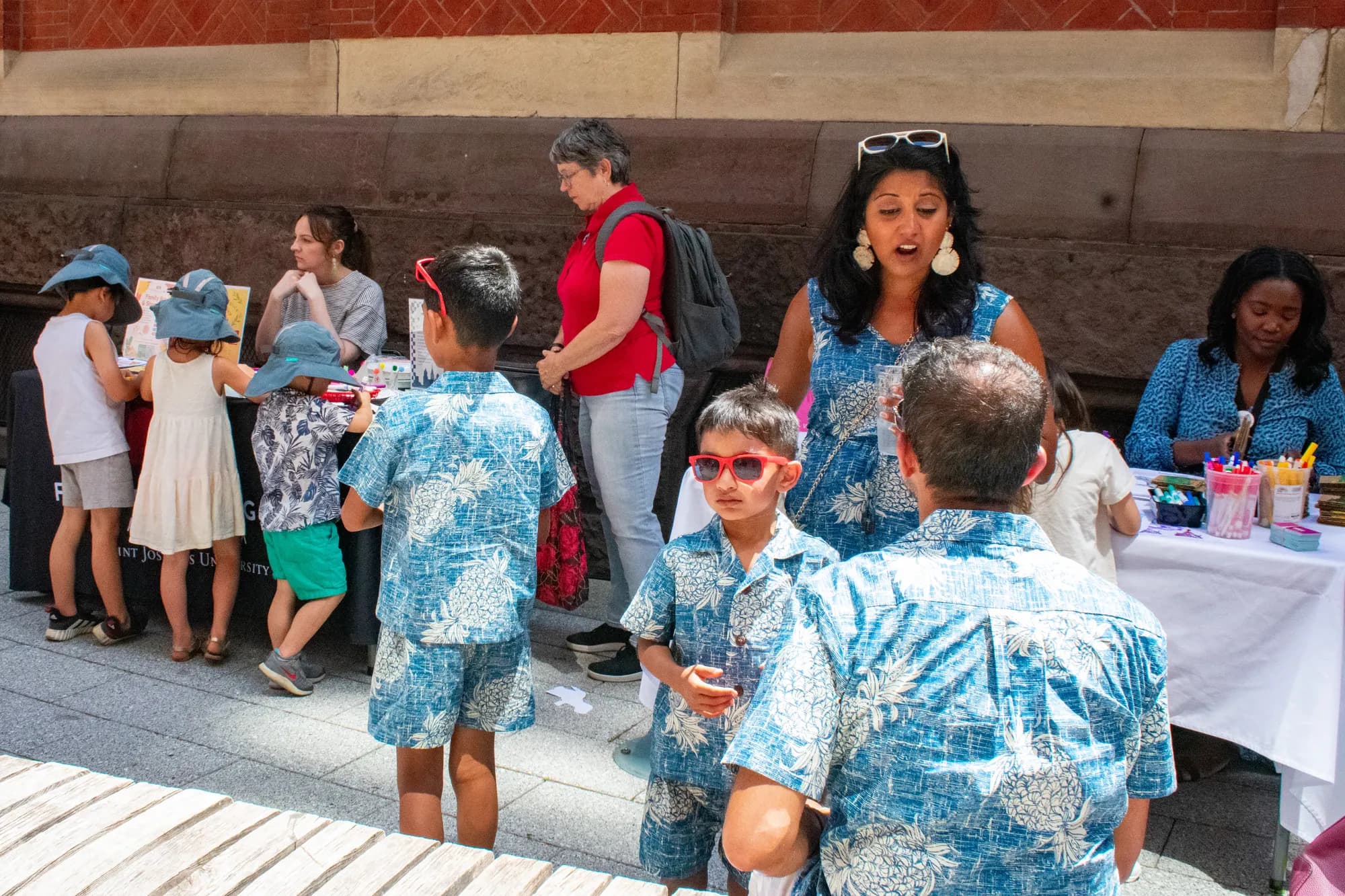 Families in matching blue-print outfits talking together in the crowd.