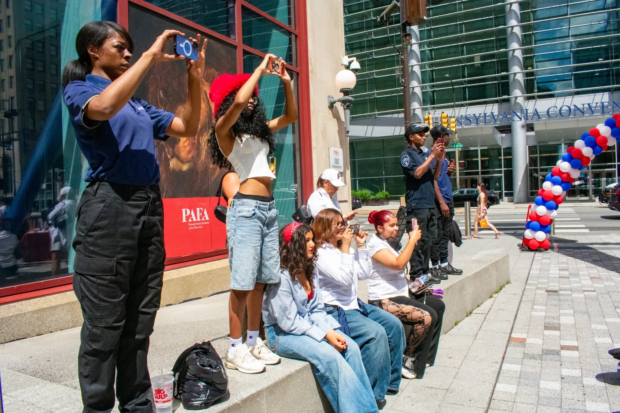 Attendees taking photographs of one another beside the PAFA banner outside.